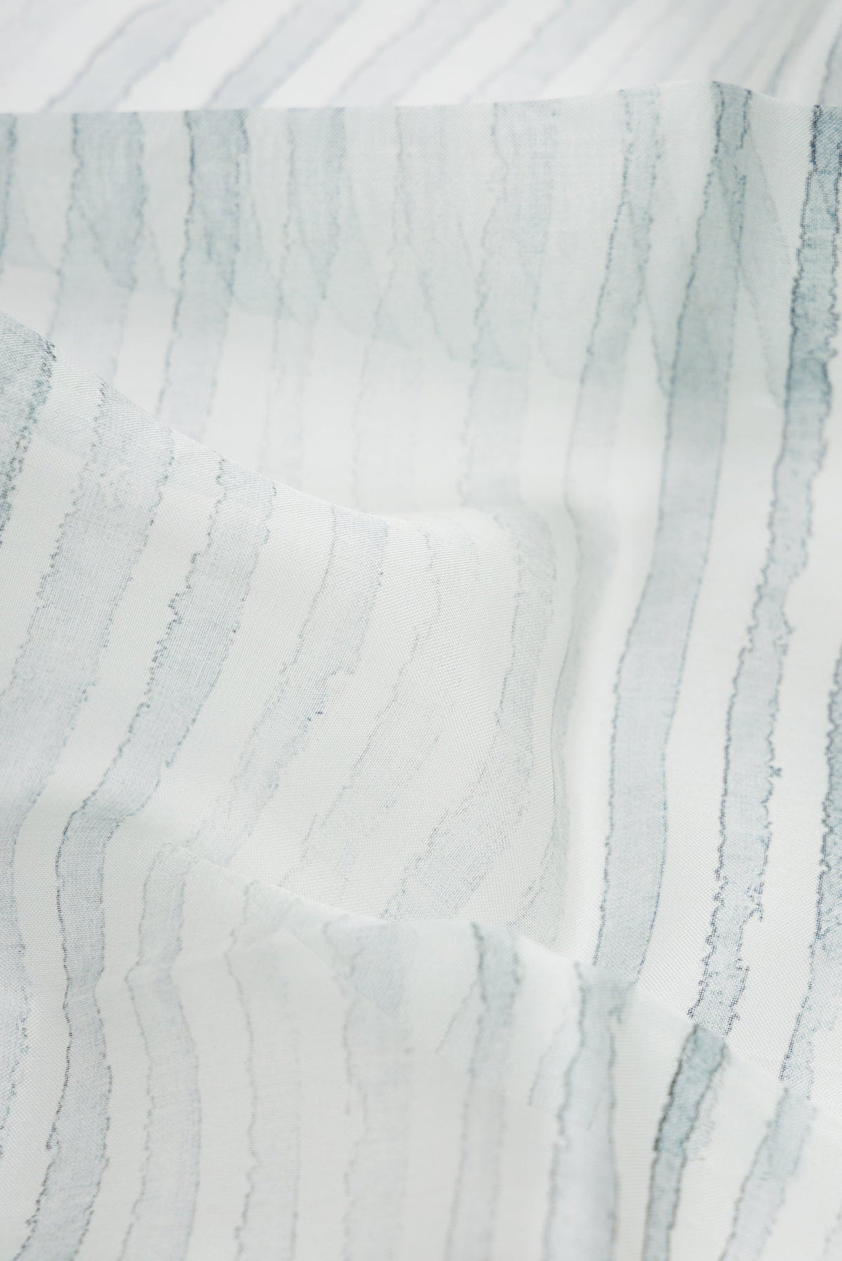 Close up of Grey Dual Tone Organza Silk Saree with Printed design on the body and Zari Border.  displaying folds