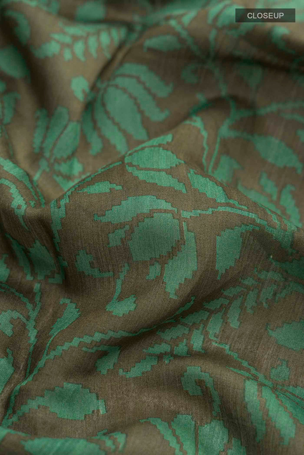 Close up of Green Tussar Silk Saree with Printed design on the body and Zari Border displaying folds