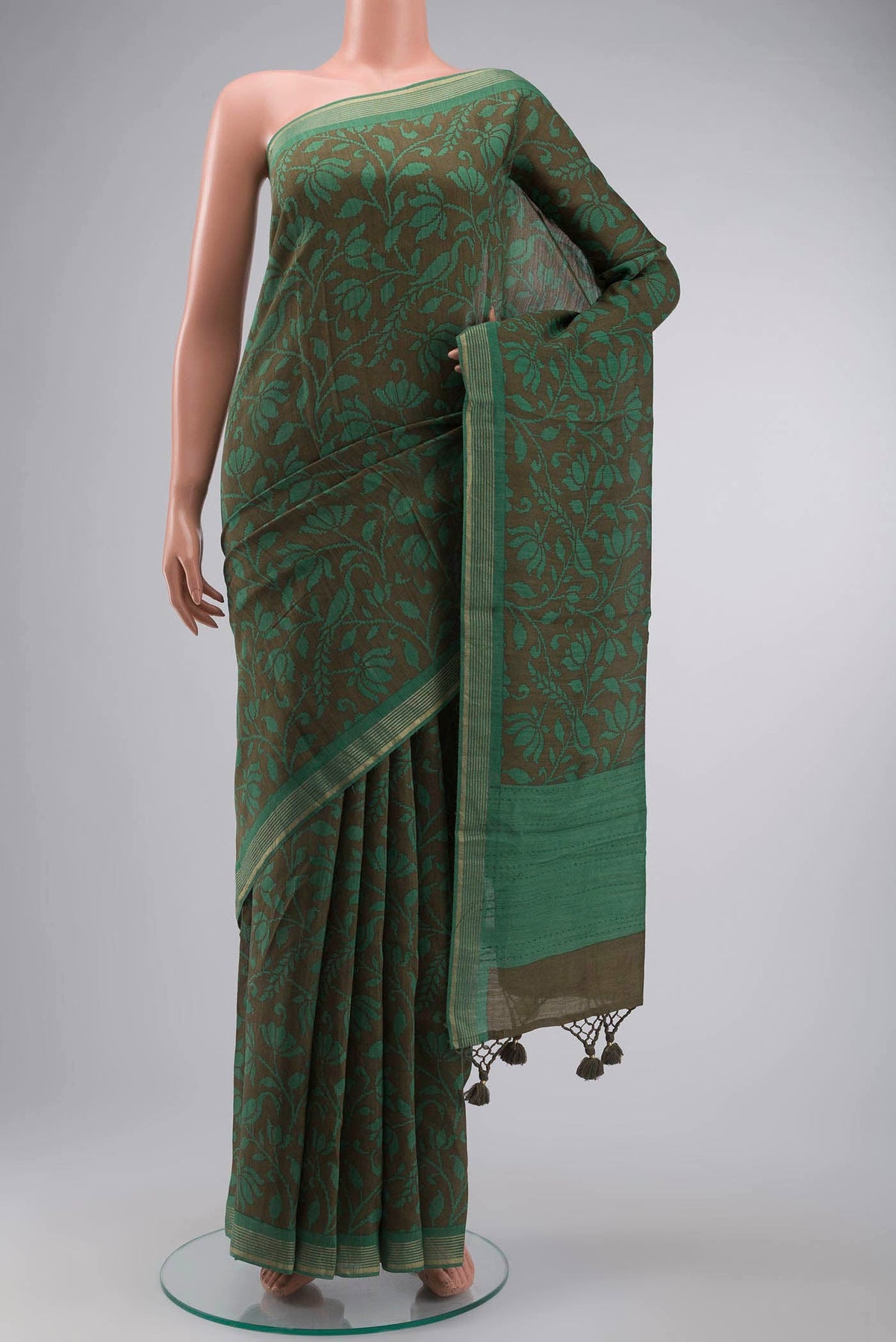 Green Tussar Silk Saree with Printed design on the body and Zari Border displayed on a mannequin