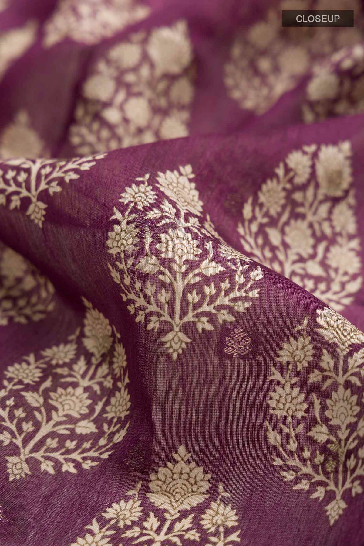 Close up of Mauve Tussar Silk Saree with Printed design on the body and Zari Border displaying folds