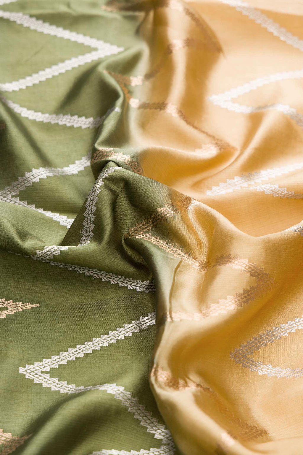 Close up of Green and Sandal Color Tussar Silk Saree with Zari Butta on the body and Plain Border displaying folds