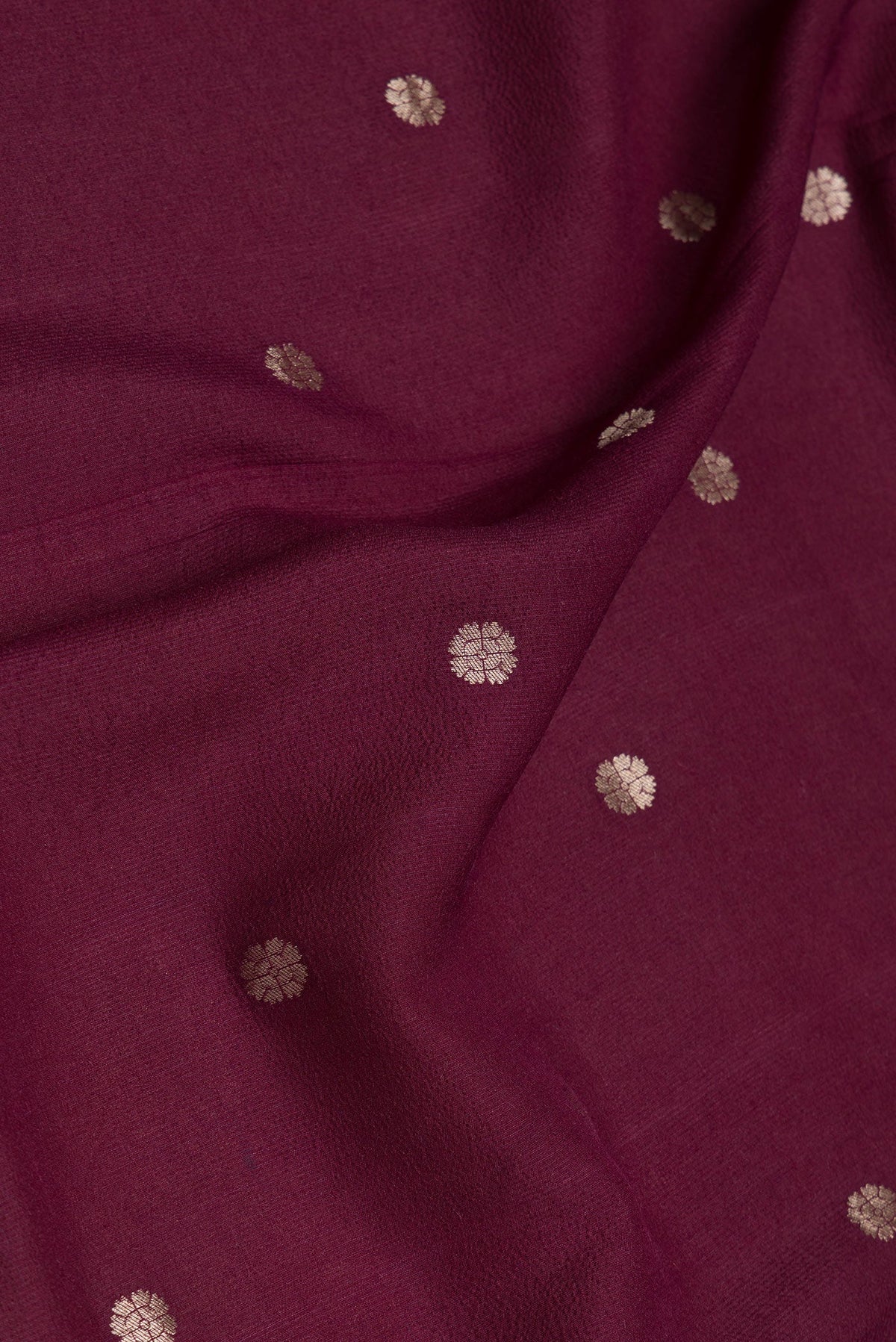 Close up of Maroon Dual Tone Tussar Silk Saree with Zari Butta on the body and Zari Border.  displaying folds