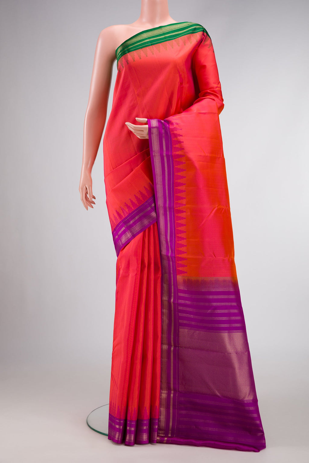 Coral Dual Tone Kanchipuram Silk Saree with Plain Body and Ganga Jamuna Border.  displayed on a mannequin