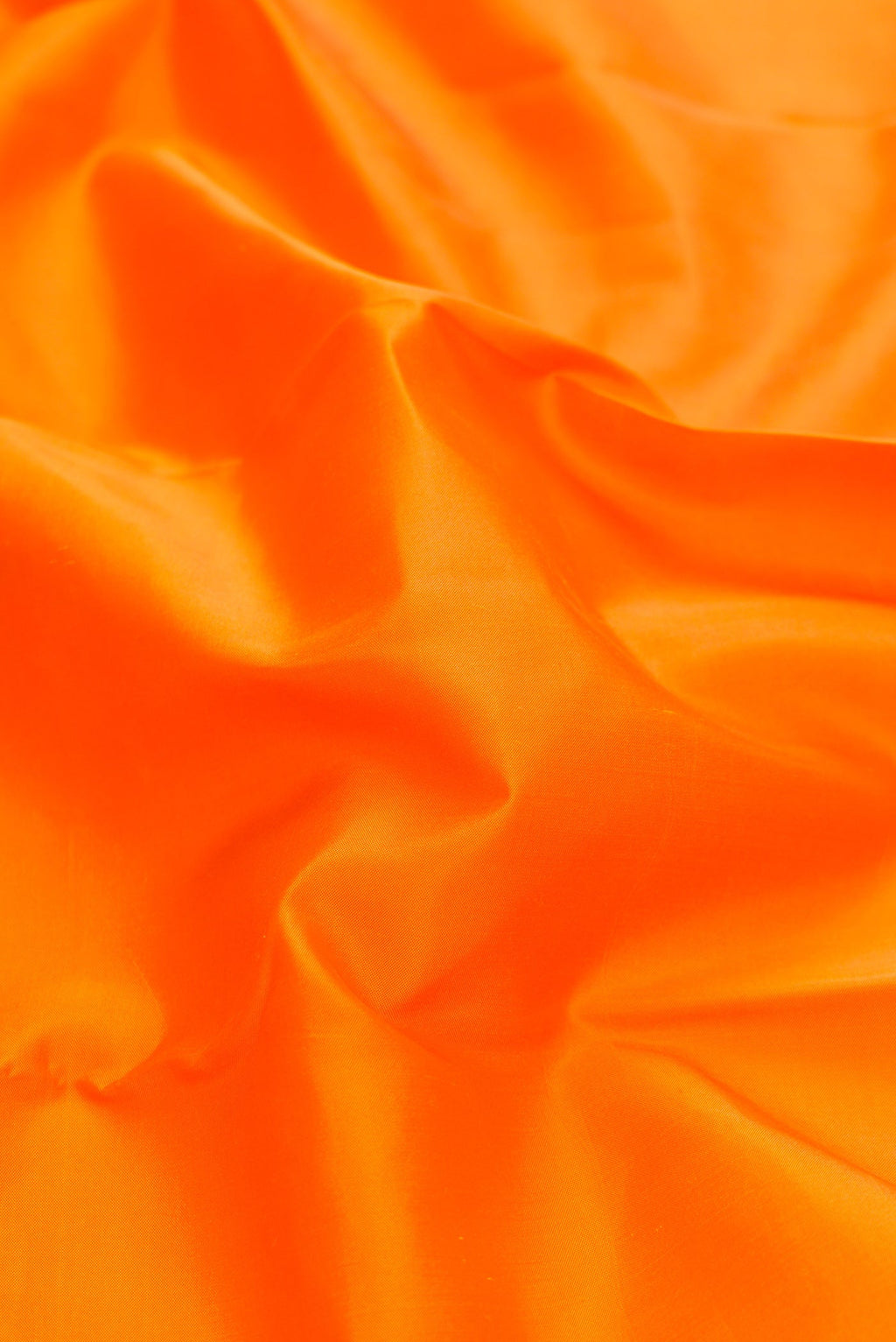 Close up of Orange Dual Tone Kanchipuram Silk Saree with Plain Body and Ganga Jamuna Border.  displaying folds