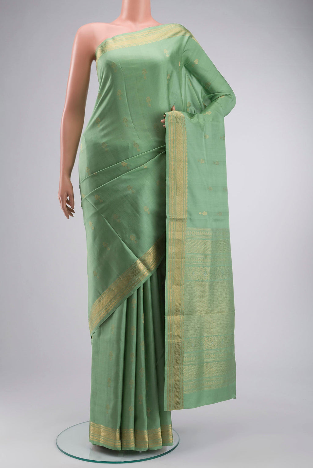 Green Soft Silk Saree with Zari Butta on the body and Zari Border displayed on a mannequin