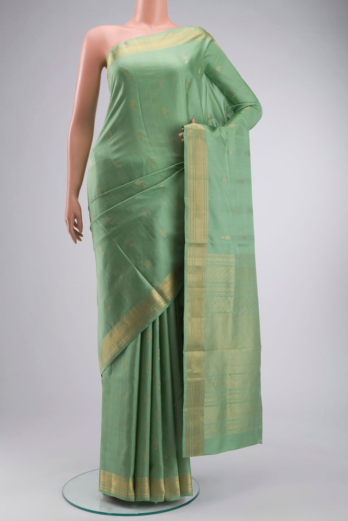 Green Soft Silk Saree with Zari Butta on the body and Zari Border displayed on a mannequin