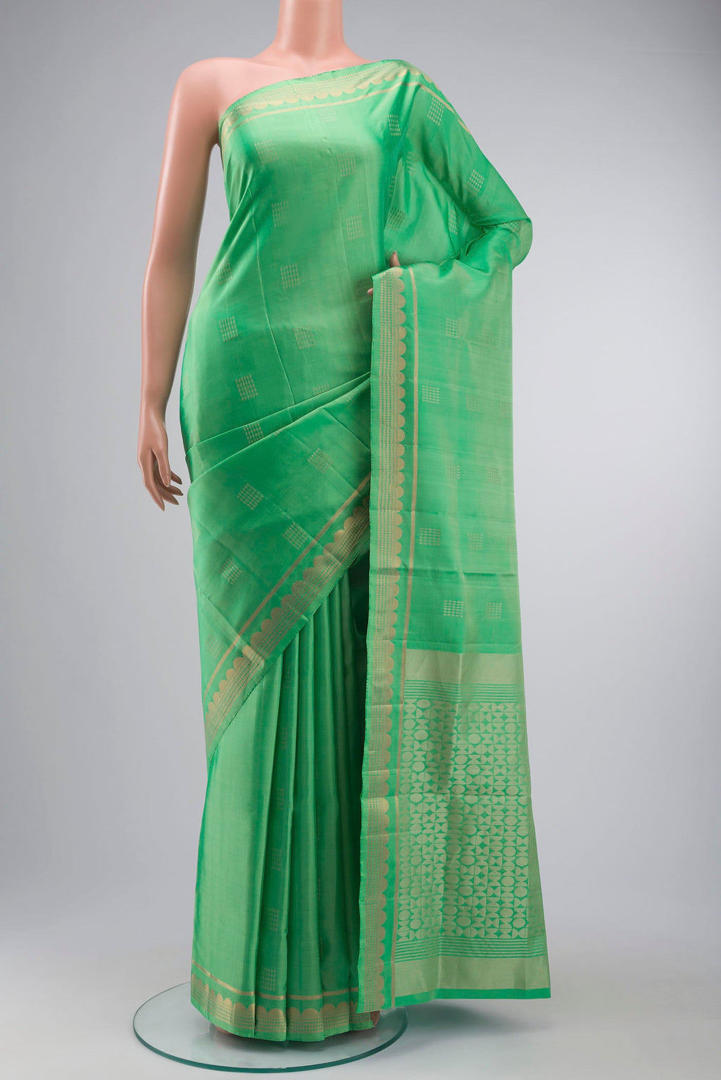 Green Soft Silk Saree with Zari Butta on the body and Zari Border displayed on a mannequin