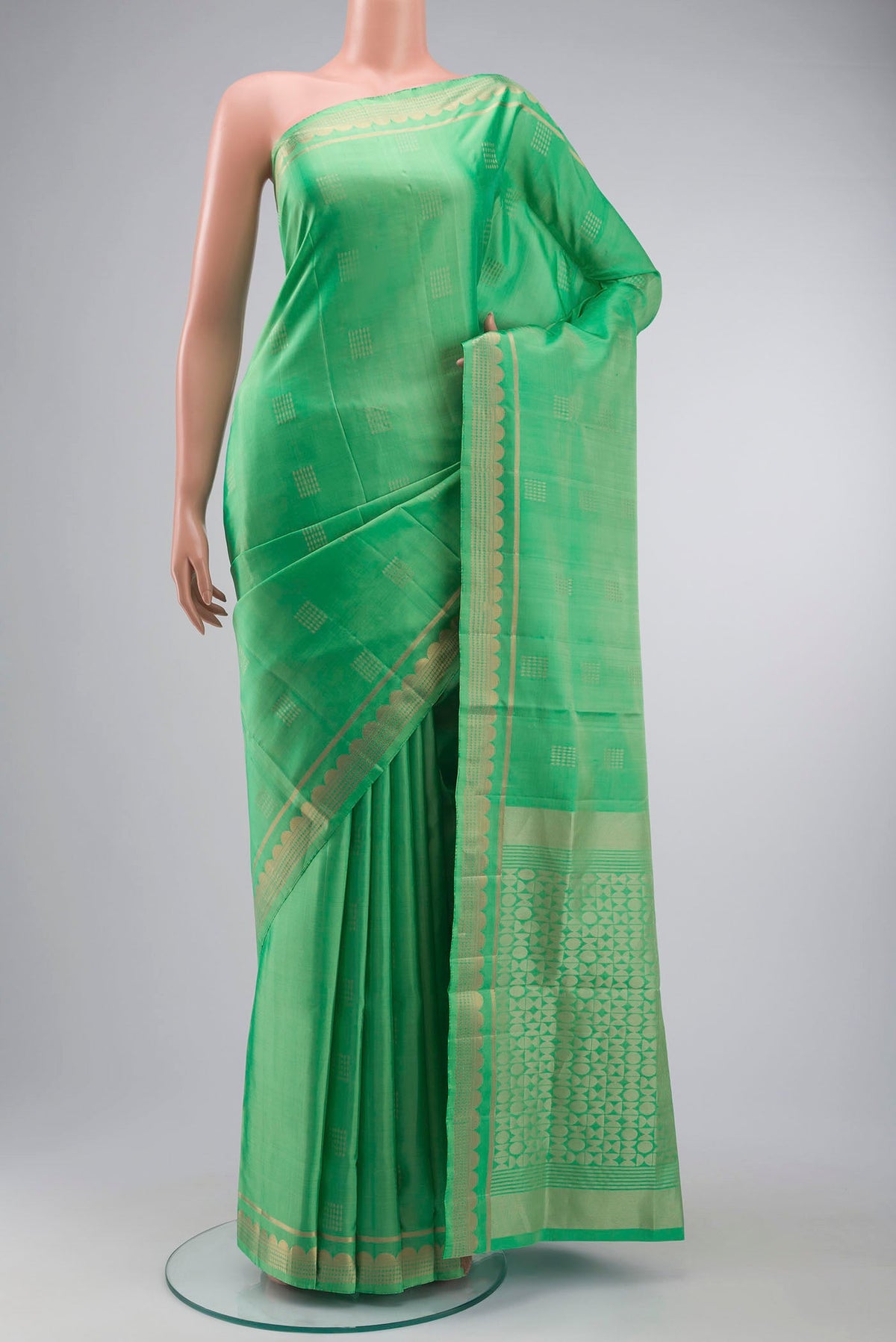 Green Soft Silk Saree with Zari Butta on the body and Zari Border displayed on a mannequin