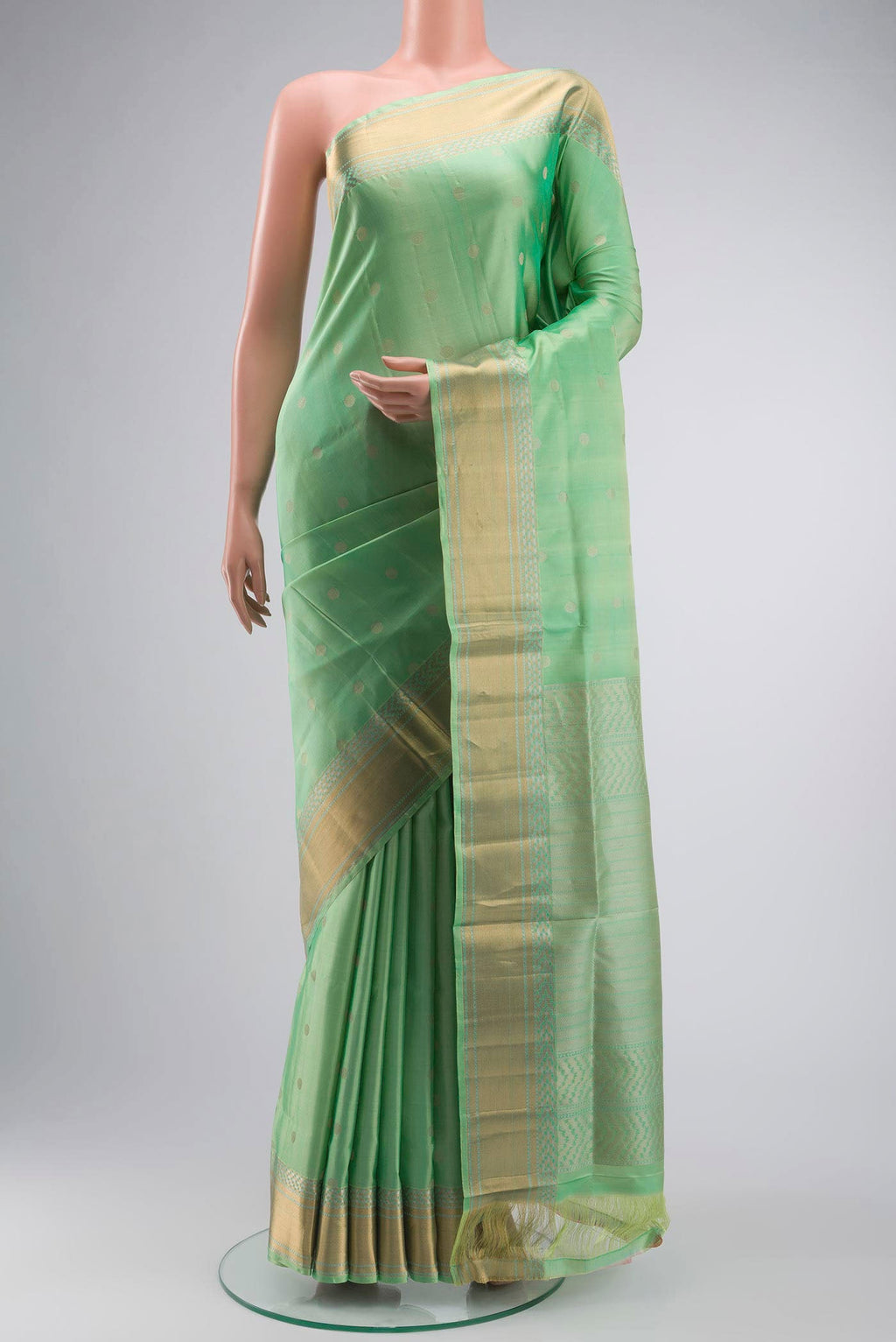 Green Soft Silk Saree with Zari Butta on the body and Zari Border displayed on a mannequin