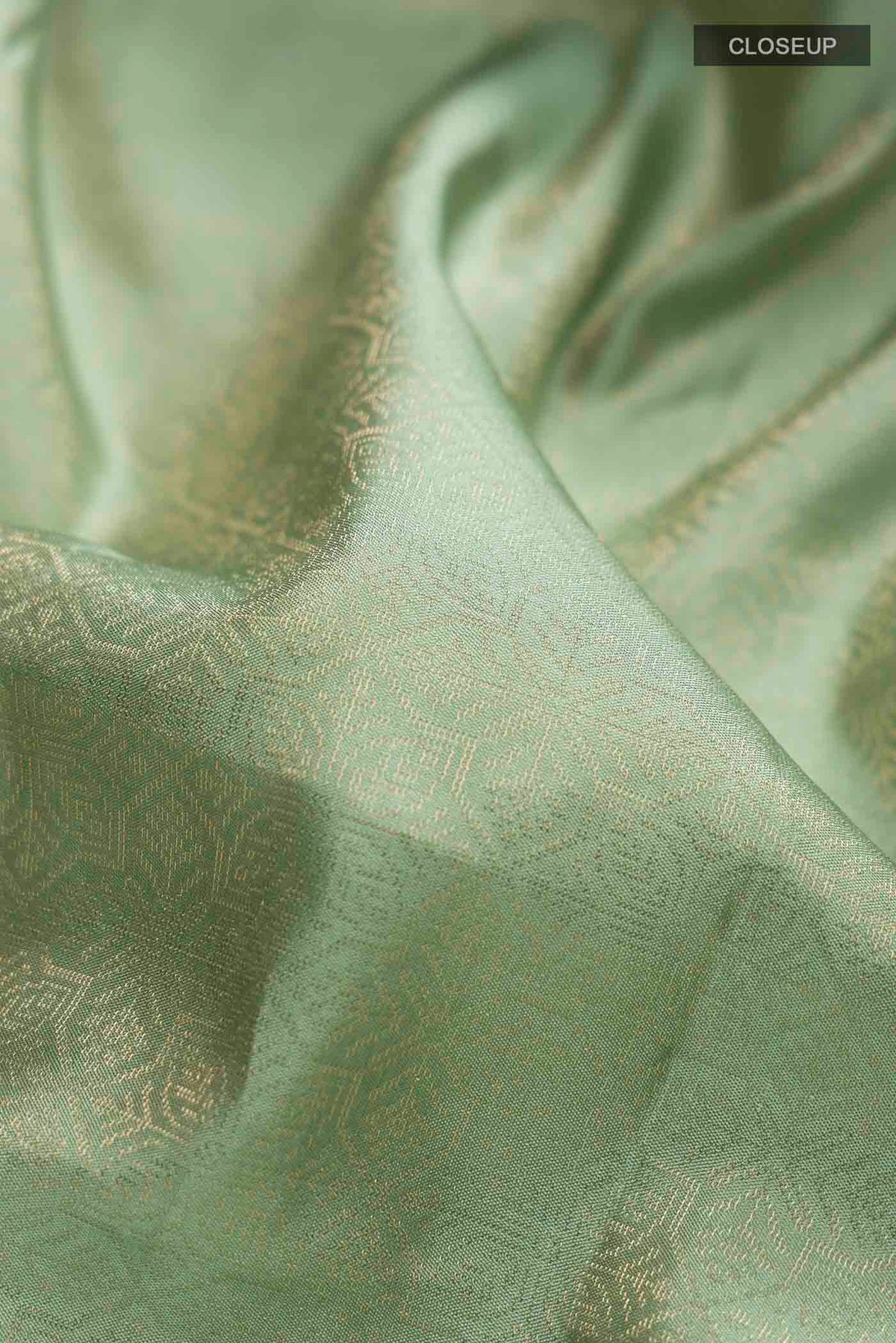 Close up of Green Soft Silk Saree with Zari Brocade on the body and Zari Border displaying folds
