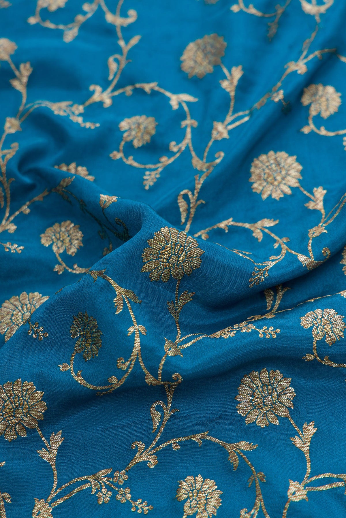 Close up of Peacock Blue Dual Tone Banarasi Georgette Saree with Zari Brocade on the body and Zari Border.  displaying folds