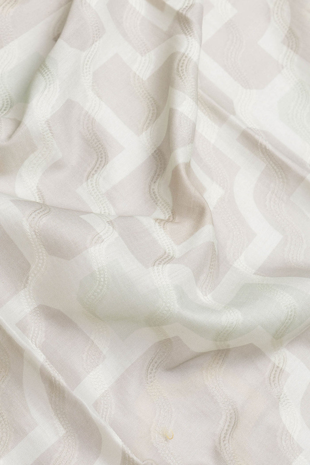 Close up of Grey Dual Tone Chanderi Silk Saree with Thread Butta on the body and Zari And Thread Border.  displaying folds