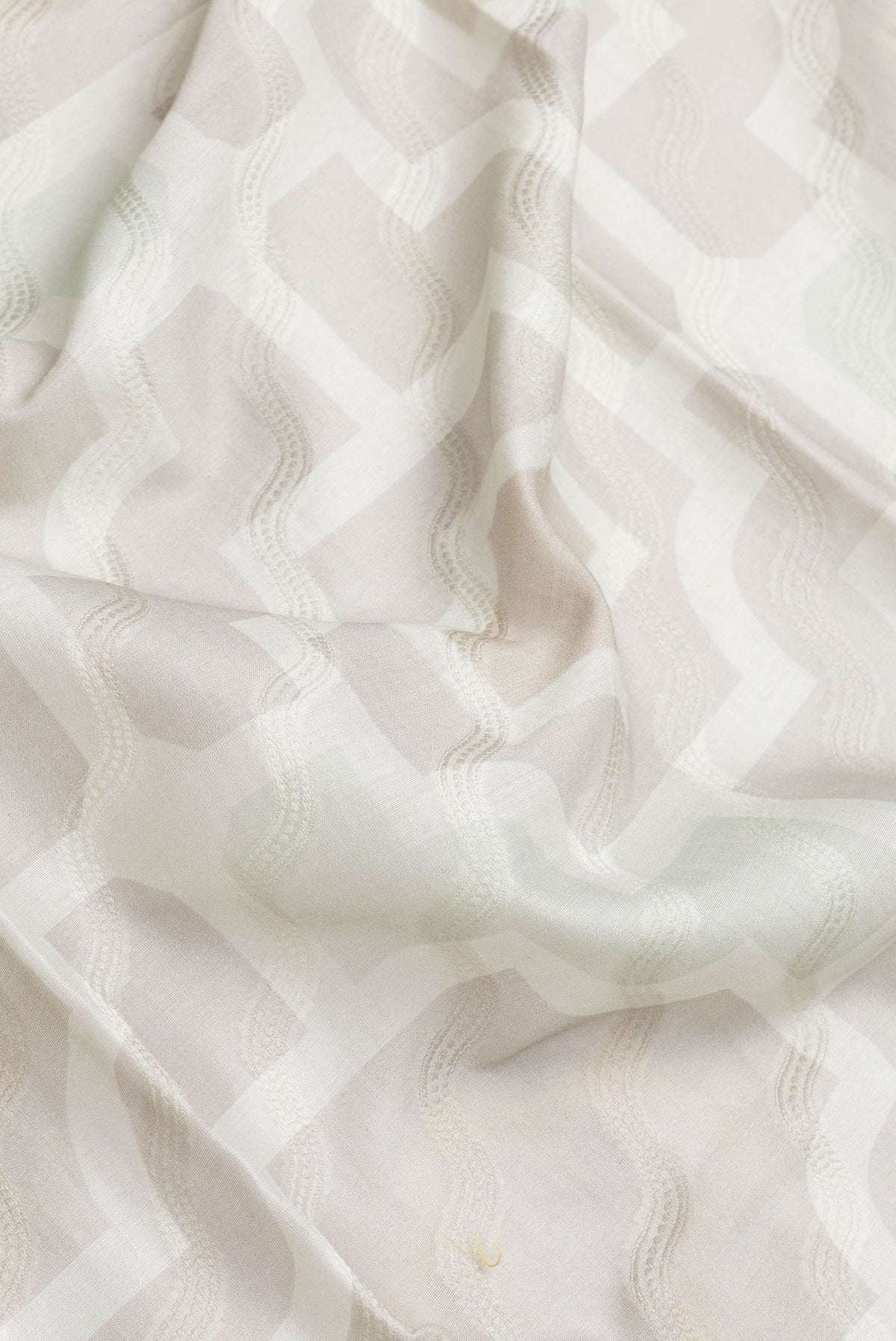 Close up of Grey Dual Tone Chanderi Silk Saree with Thread Butta on the body and Zari And Thread Border.  displaying folds