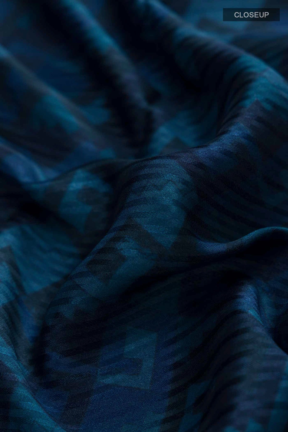 Close up of Blue Mysore Crepe Saree with Printed design on the body and Zari Border displaying folds