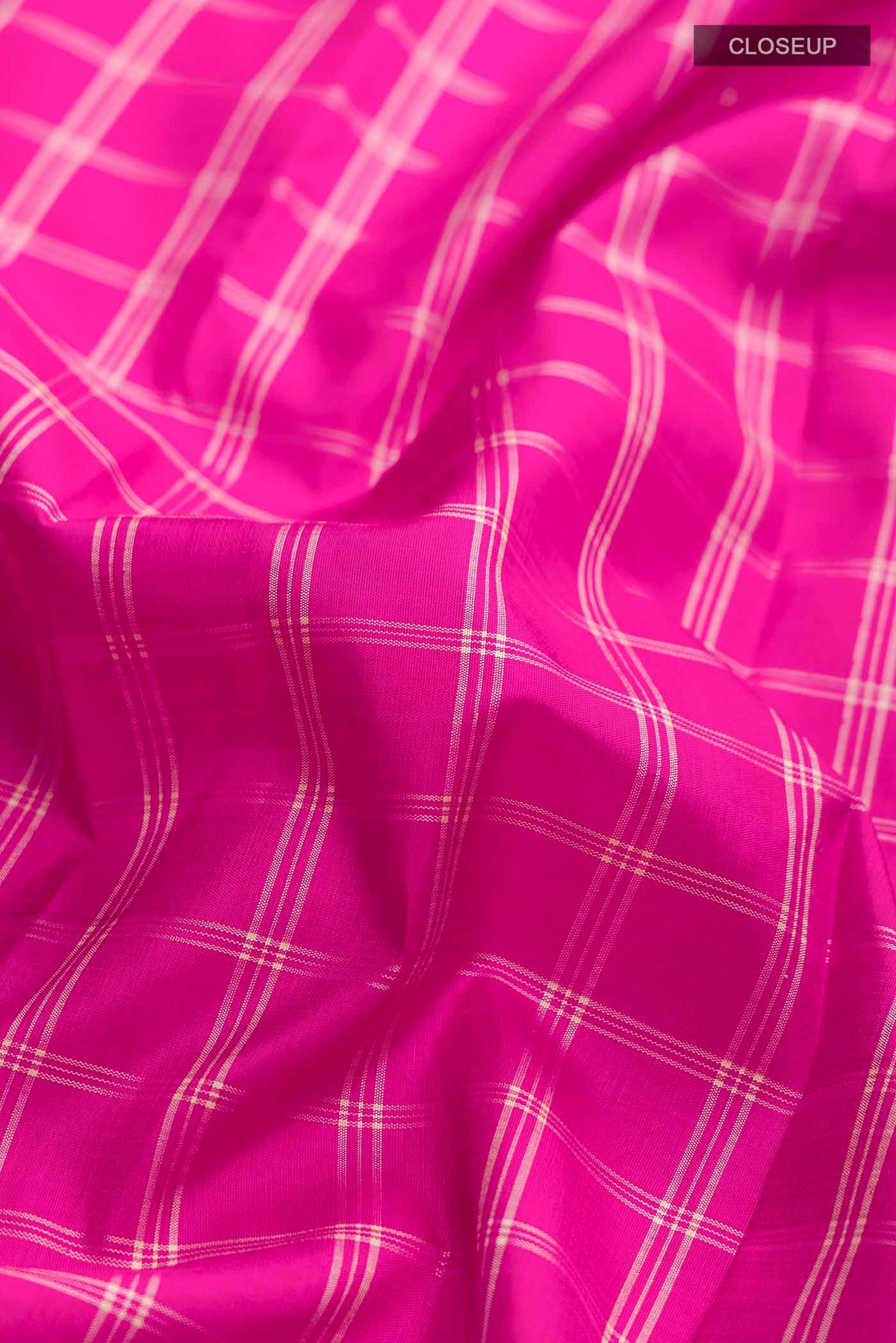 Close up of Pink Kanchipuram Silk Saree with Checked design on the body and Plain Border displaying folds