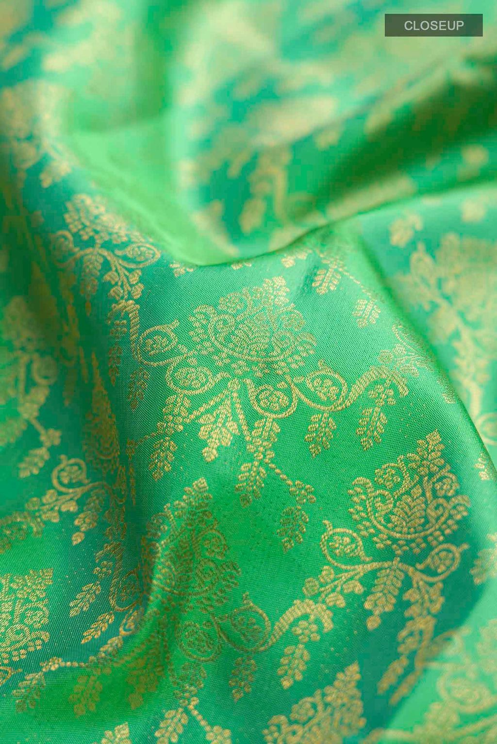 Close up of Green Kanchipuram Silk Saree with Zari Brocade on the body and Zari Border displaying folds
