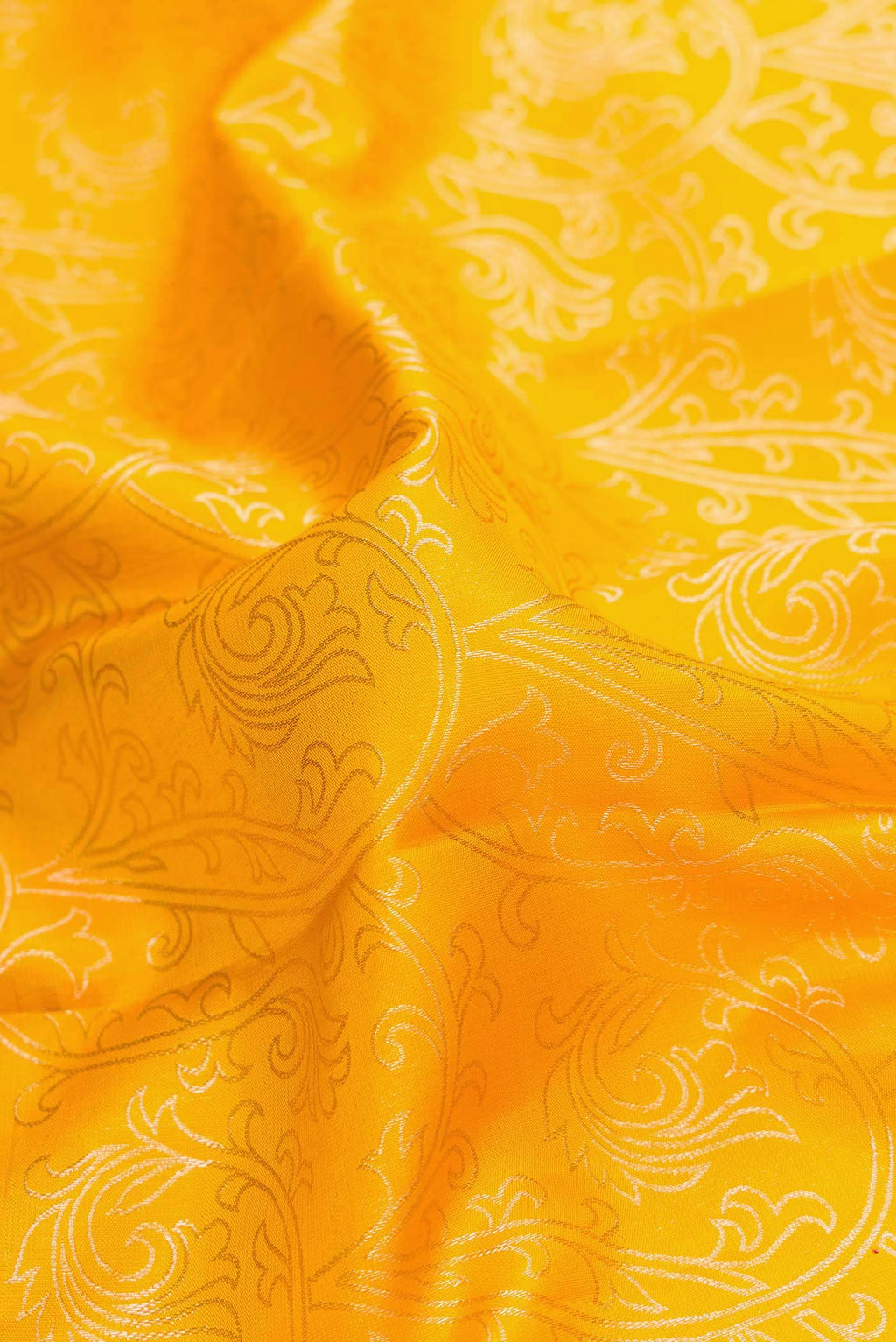 Close up of Yellow Dual Tone Kanchipuram Silk Saree with Zari Brocade on the body and Zari Border.  displaying folds