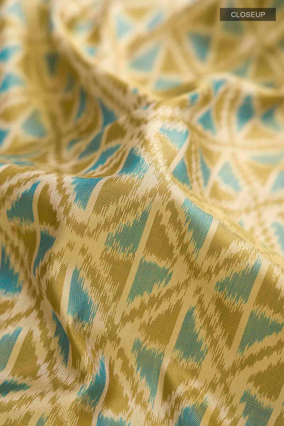 Close up of Green Pochampally Silk Saree with Pure Ikat on the body and Zari Border displaying folds