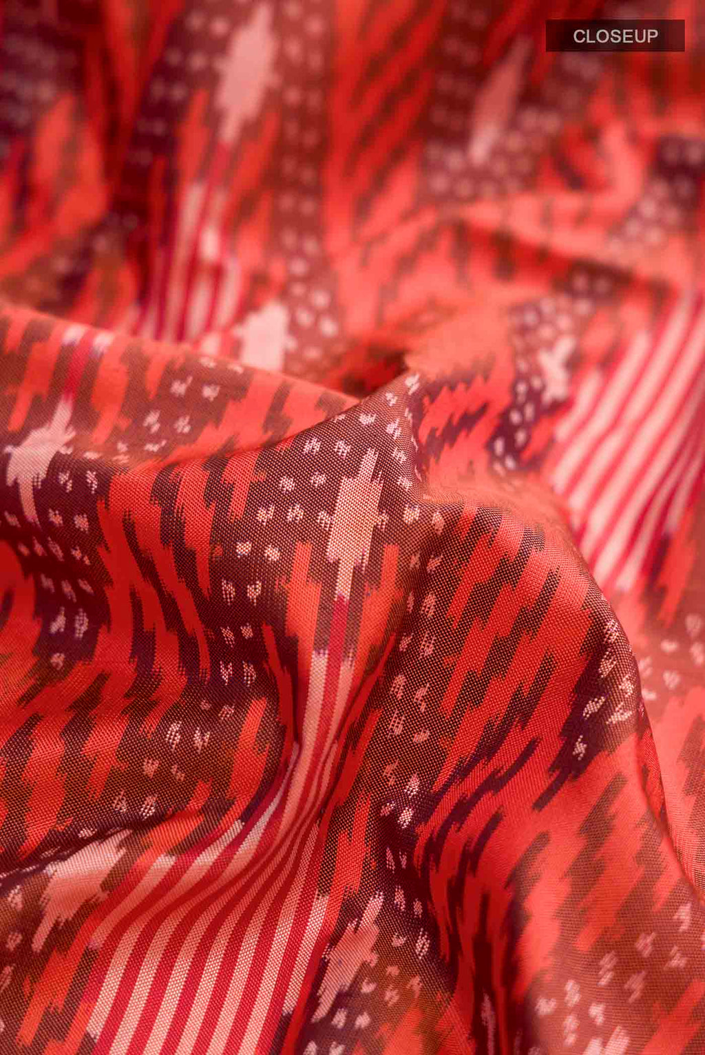 Close up of Orange Pochampally Silk Saree with Pure Ikat on the body and Plain Border displaying folds