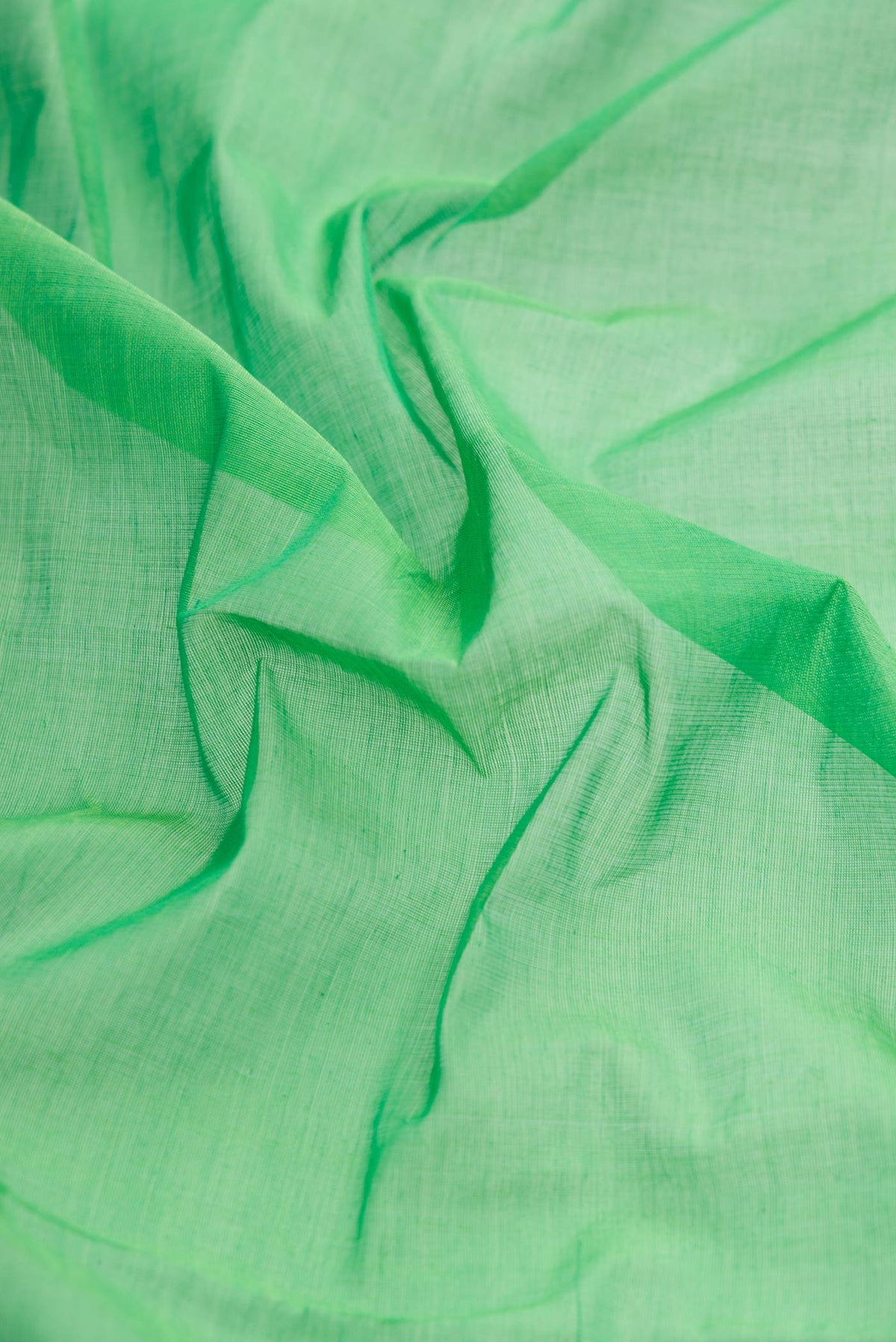 Close up of Green Dual Tone Uppada Cotton Saree with Plain Body and Plain Border displaying folds