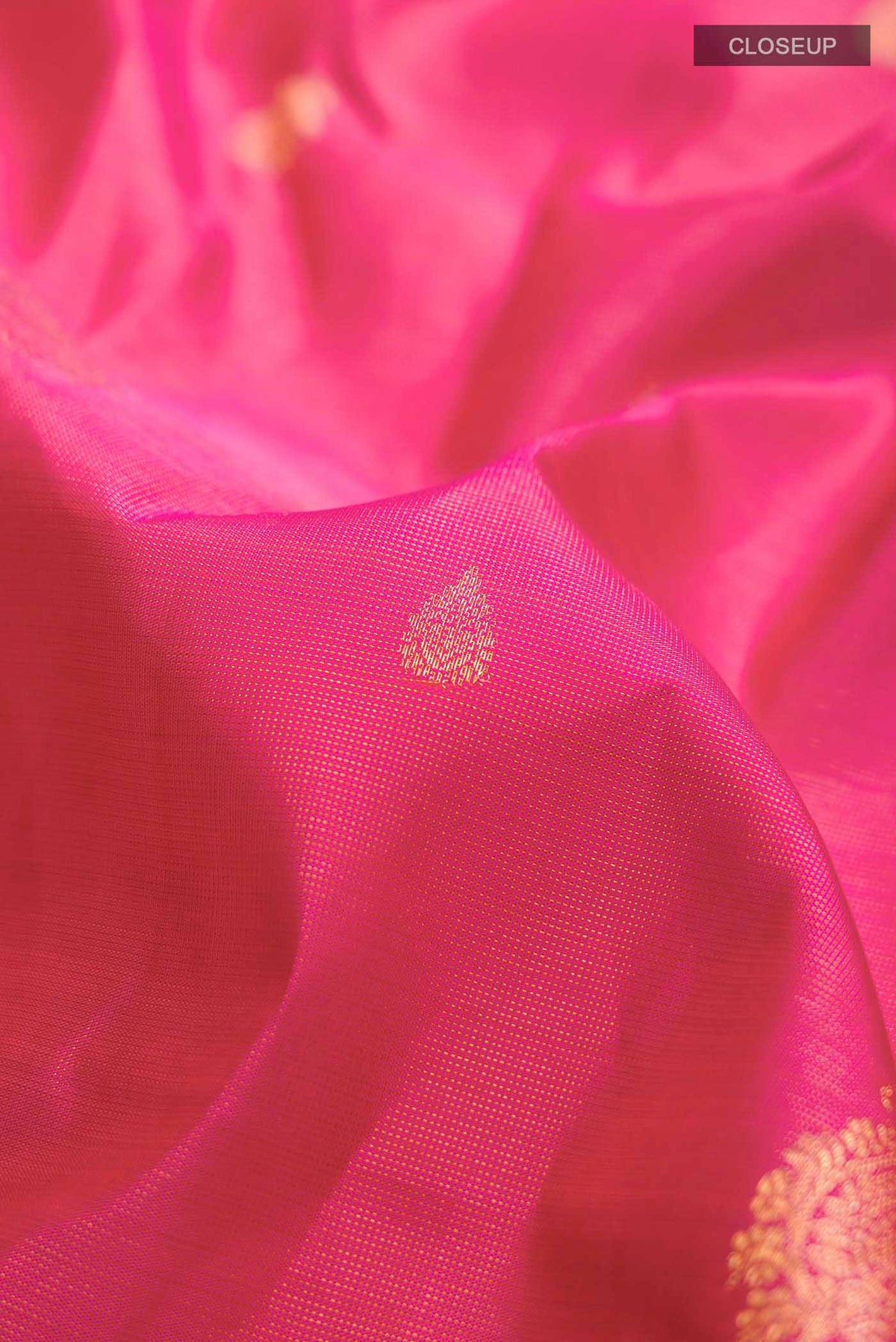 Close up of Pink Kanchipuram Silk Saree with Zari Butta on the body and Zari Border displaying folds