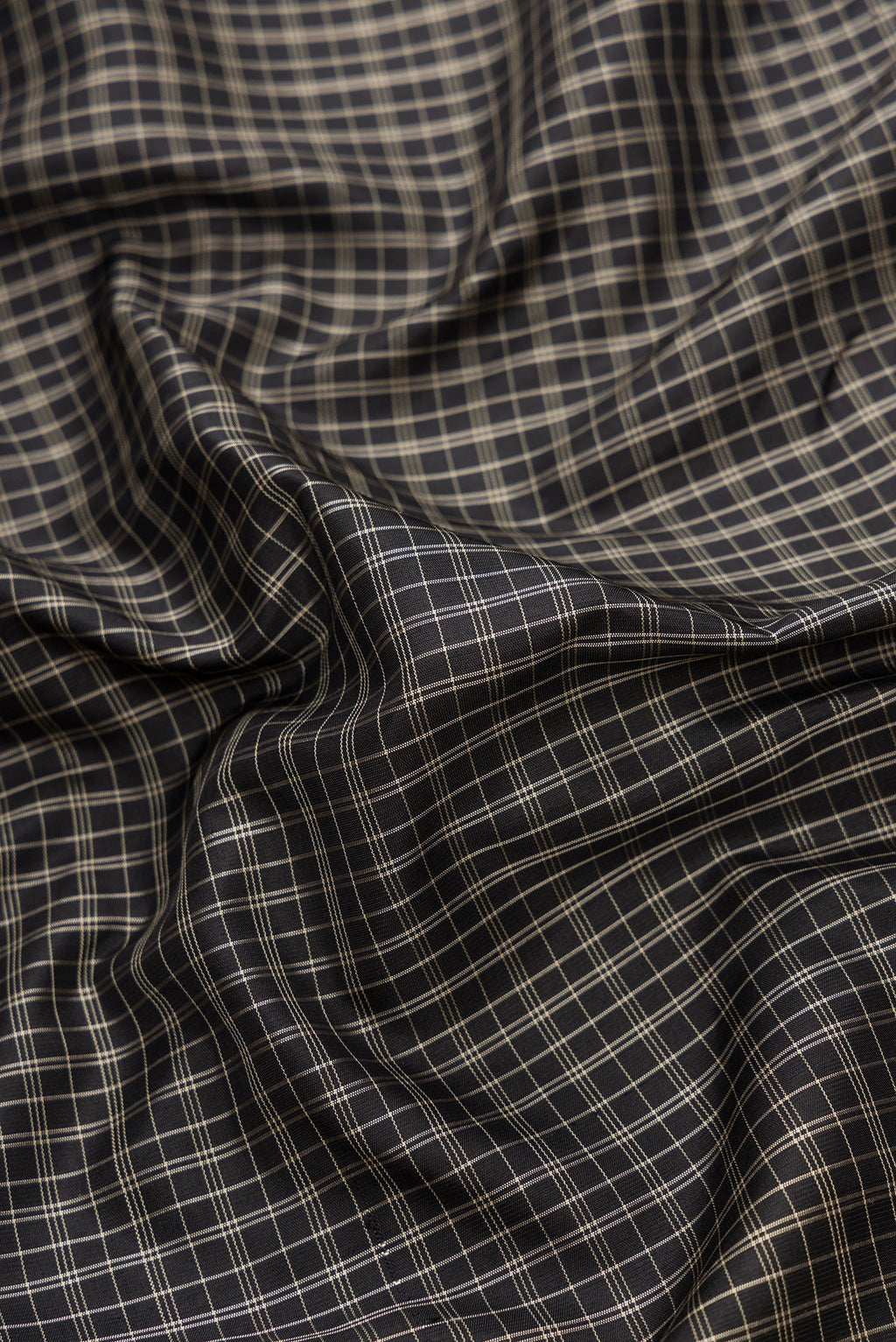 Close up of Black Dual Tone Gadwal Silk Saree with Checked design on the body and Temple Border.  displaying folds
