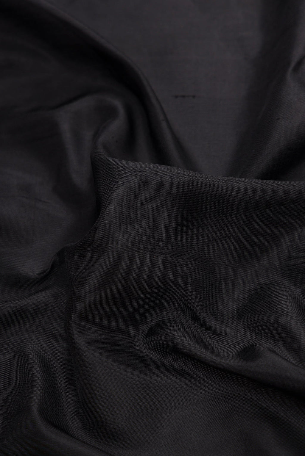 Close up of Black Dual Tone Gadwal Silk Saree with Plain Body and Thread Border.  displaying folds