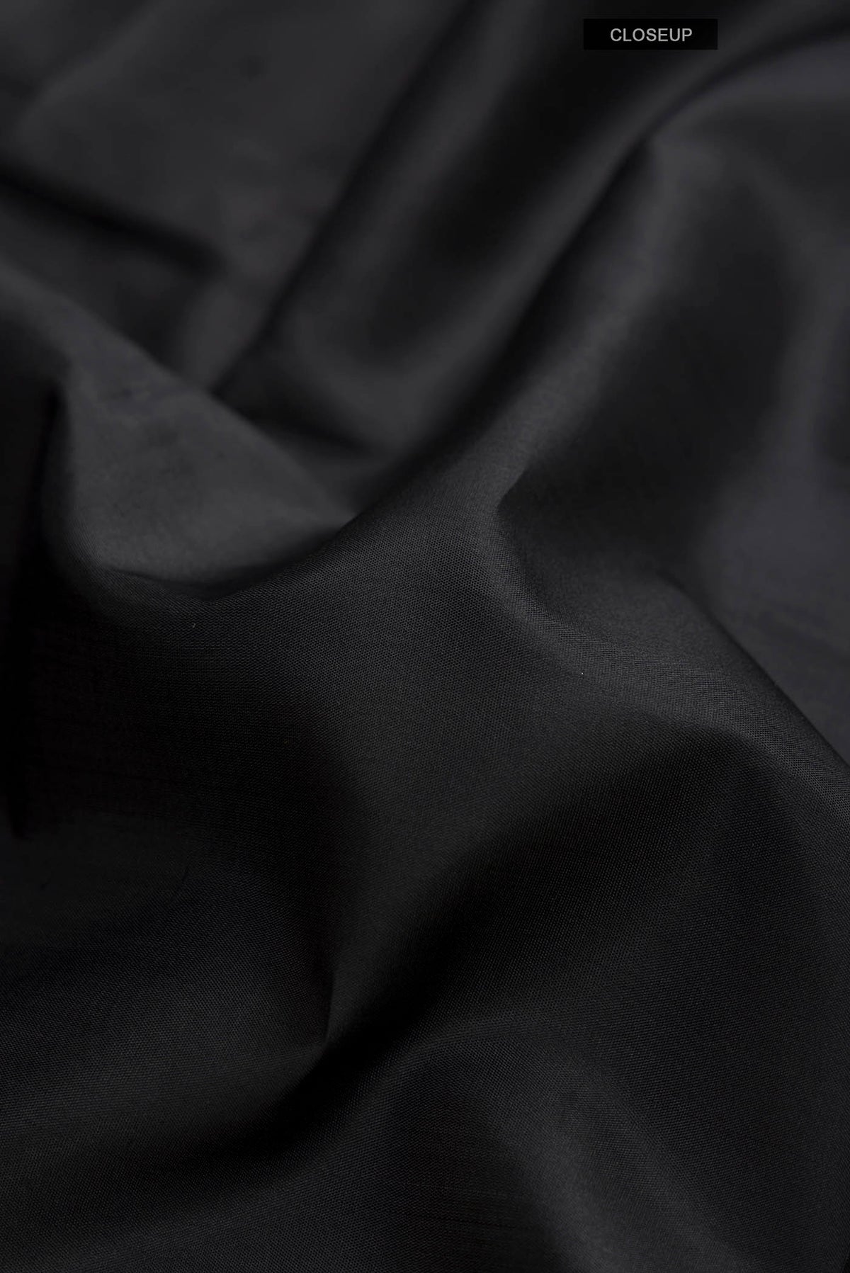Close up of Black Kanchipuram Silk Saree with Plain Body and Zari Border displaying folds