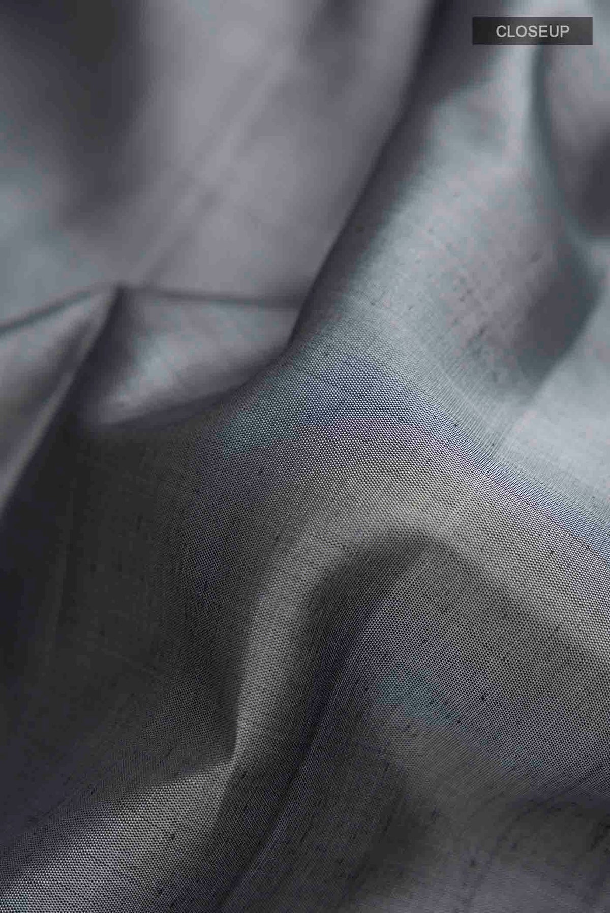 Close up of Grey Kanchipuram Silk Saree with Plain Body and Zari Border displaying folds