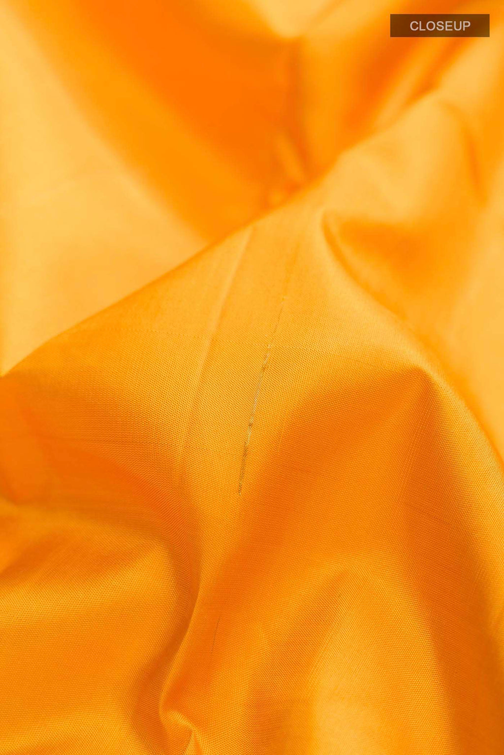 Close up of Yellow Kanchipuram Silk Saree with Zari Butta on the body and Zari Border displaying folds