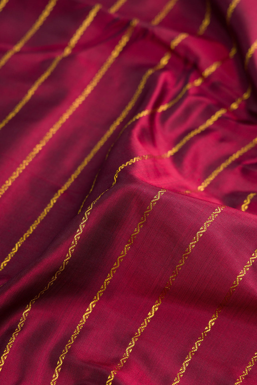 Close up of Pure Silk Pure Zari Maroon Dual Tone Kanchipuram Nine Yards Saree with Stripes on the body and Zari Border.  displaying folds