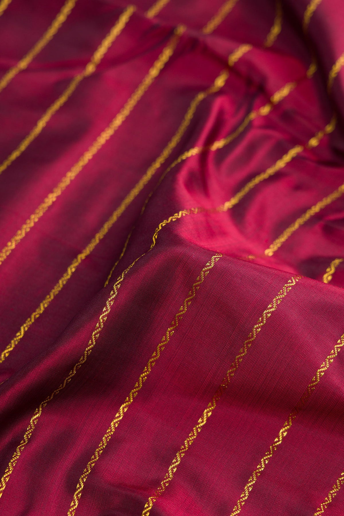 Close up of Pure Silk Pure Zari Maroon Dual Tone Kanchipuram Nine Yards Saree with Stripes on the body and Zari Border.  displaying folds