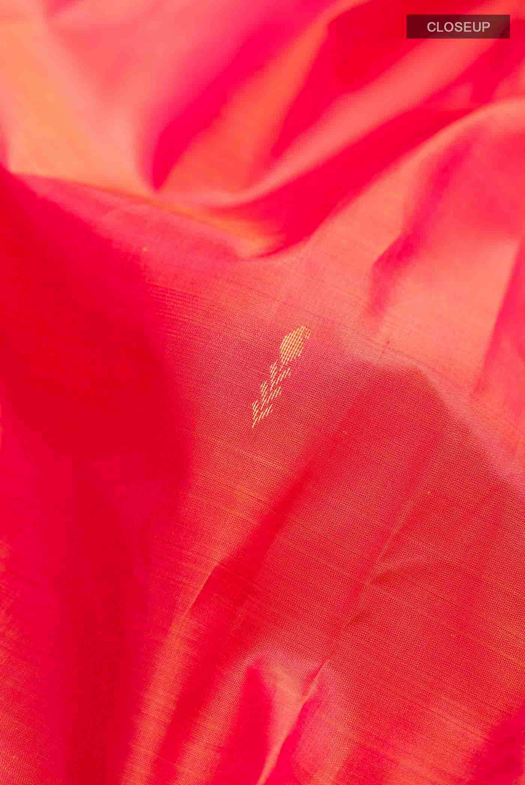 Close up of Orange Kanchipuram Silk Saree with Zari Butta on the body and Zari Border displaying folds