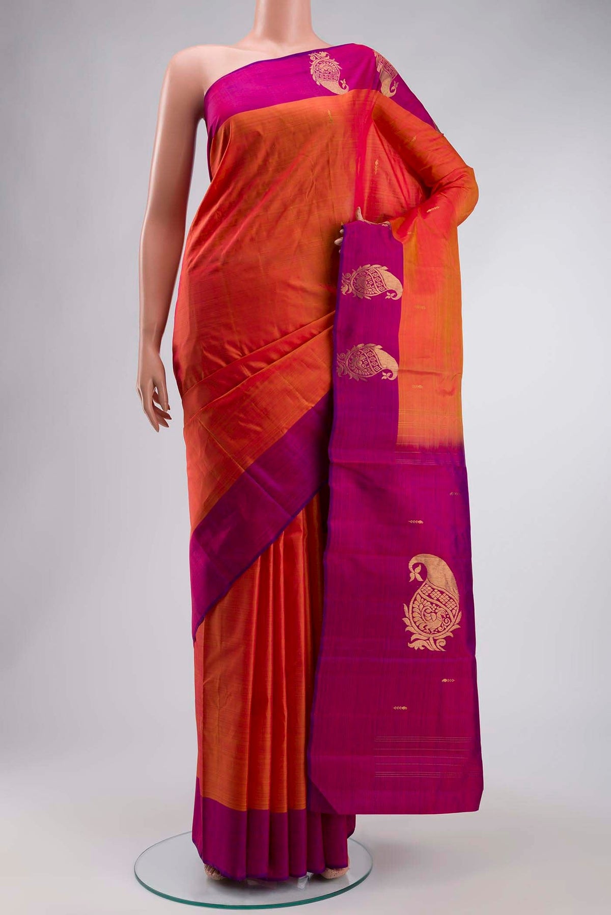 Orange Kanchipuram Silk Saree with Zari Butta on the body and Zari Border displayed on a mannequin