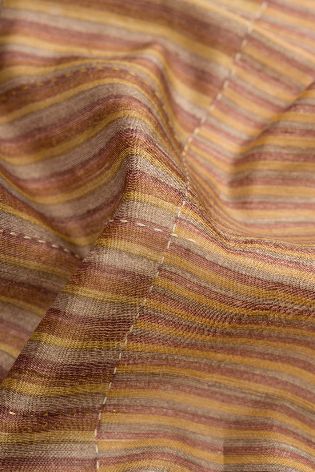 Close up of Mustard Dual Tone Tussar Silk Saree with Stripes on the body and Embroidery Border.  displaying folds