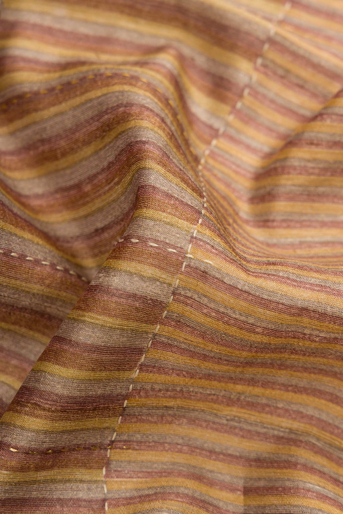 Close up of Mustard Dual Tone Tussar Silk Saree with Stripes on the body and Embroidery Border.  displaying folds