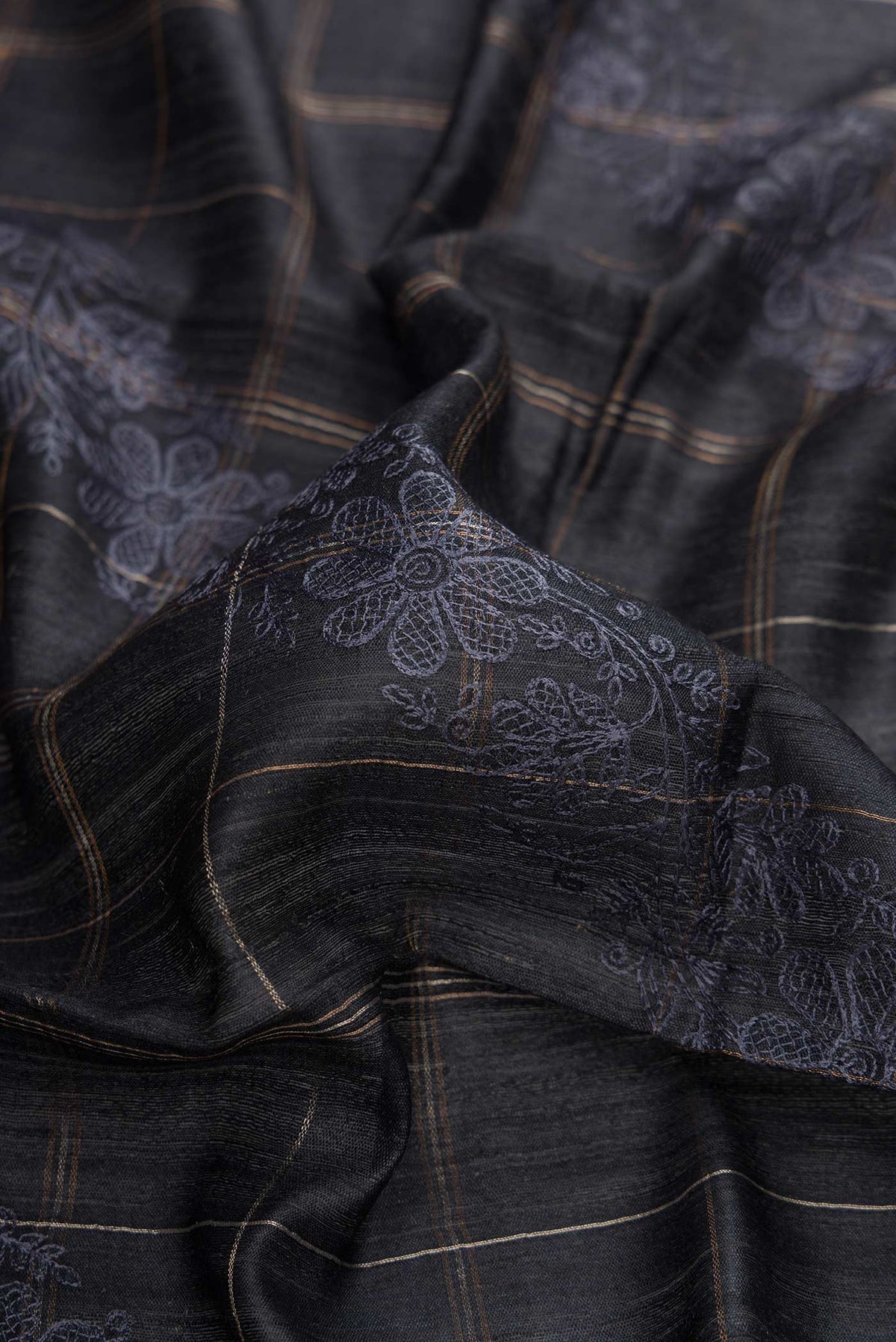 Close up of Black Dual Tone Tussar Silk Saree with Checked design on the body and Zari Border displaying folds