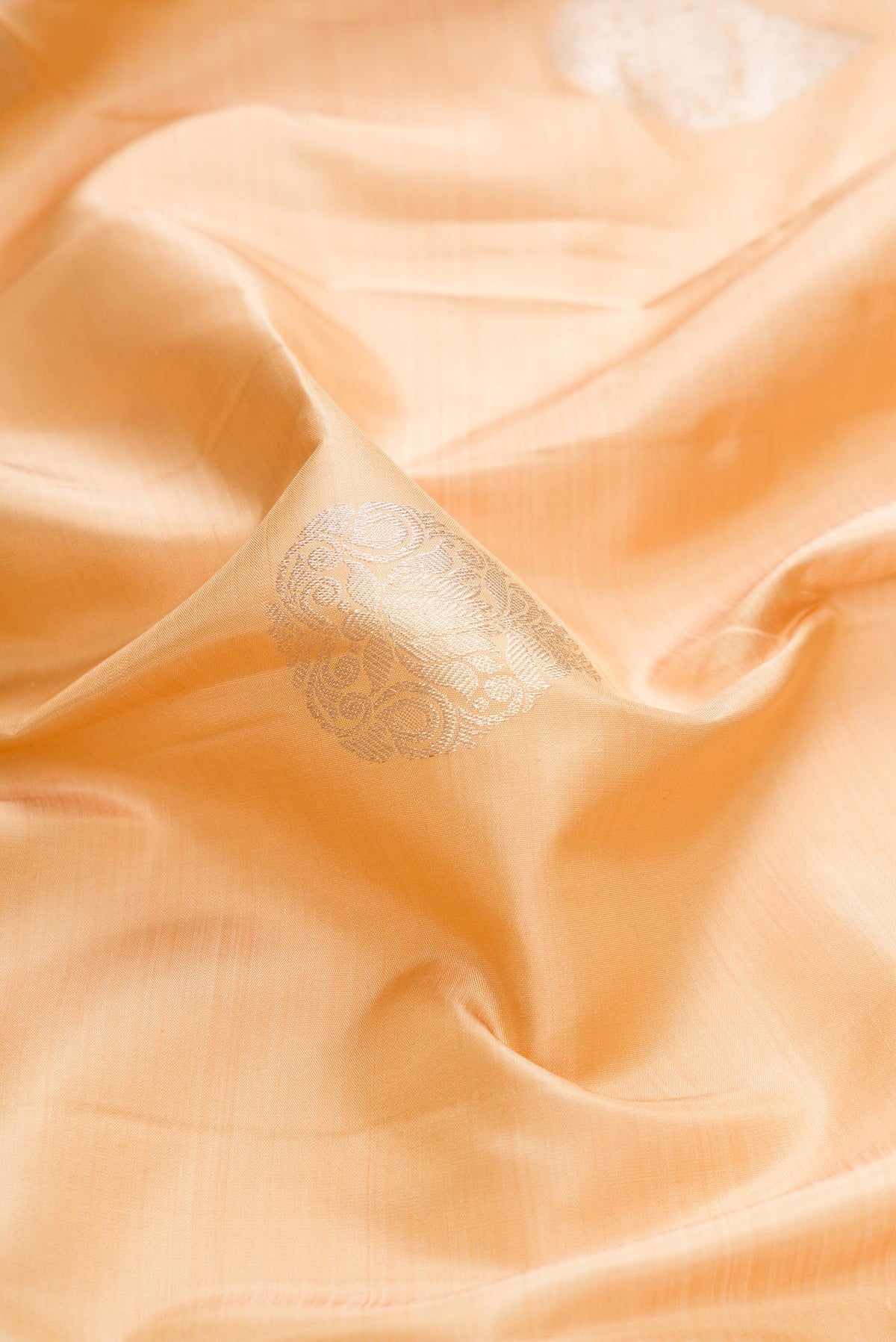 Close up of Sandal Dual Tone Kanchipuram Silk Saree with Zari Butta on the body and Zari Border displaying folds