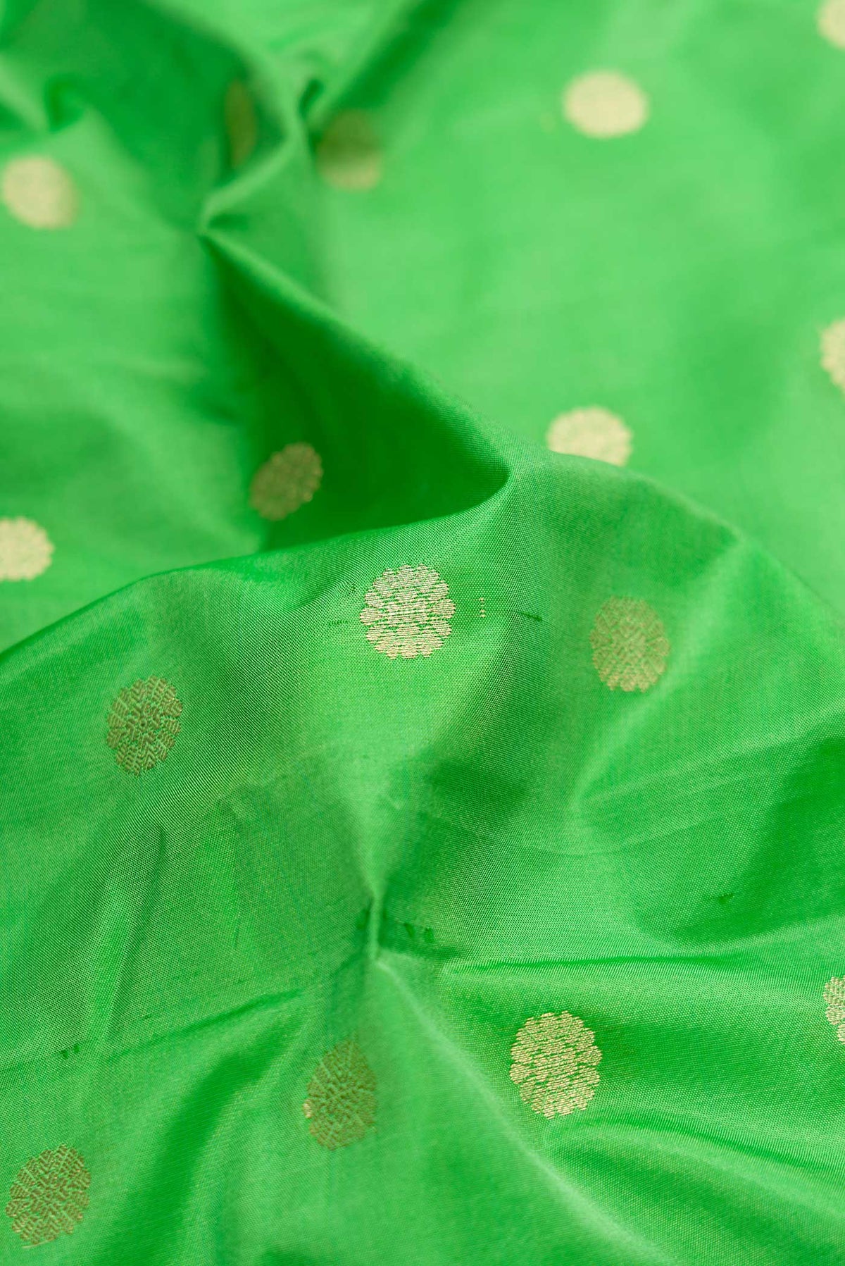 Close up of Green Blended Bangalore Silk Saree with Zari Butta on the body and Zari Border displaying folds