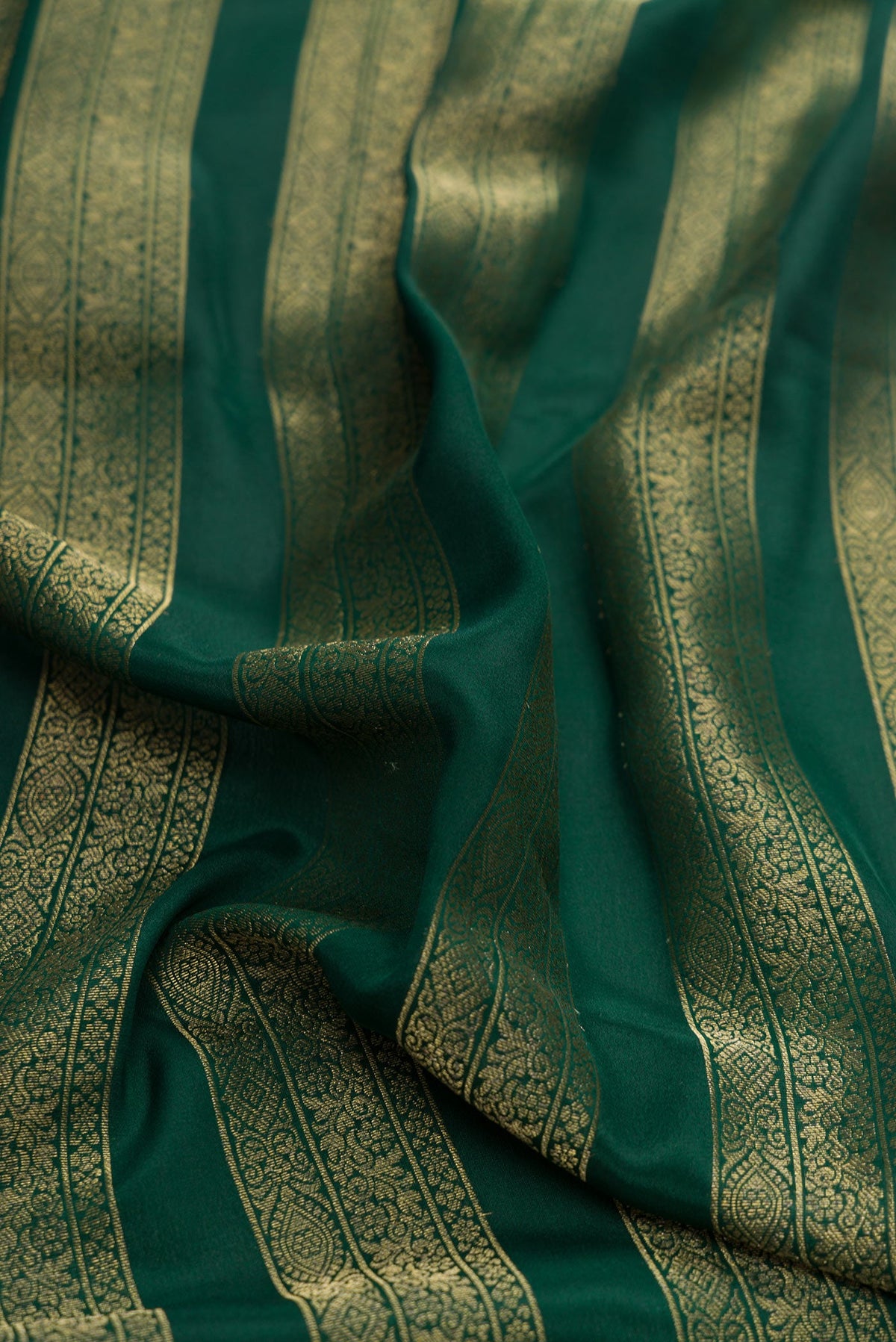 Close up of Bottle Green Dual Tone Mysore Silk Saree with Stripes on the body and Zari Border.  displaying folds
