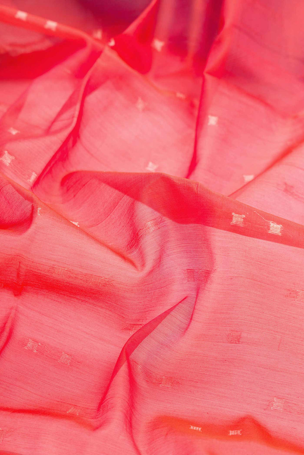 Close up of Orange Dual Tone Silk Cotton Saree with Zari Butta on the body and Zari Border displaying folds