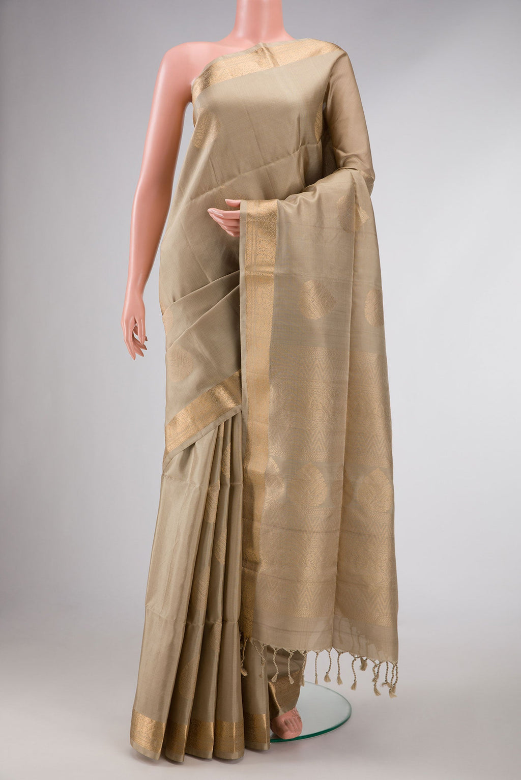 Beige Dual Tone Soft Silk Saree with Zari Butta on the body and Zari Border displayed on a mannequin