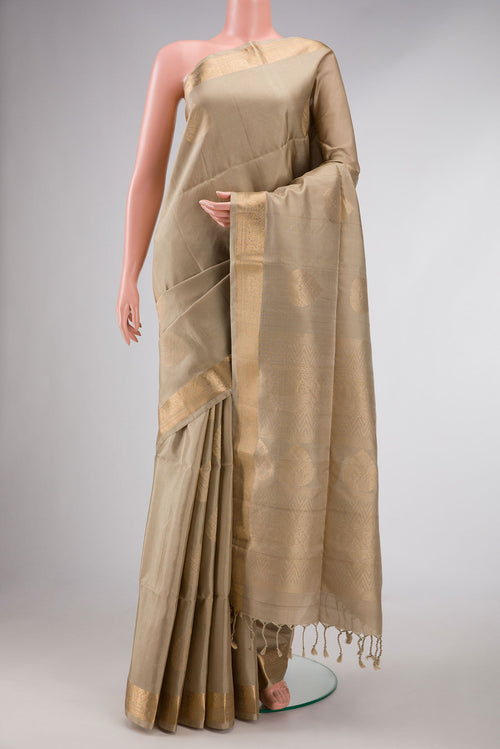 Beige Dual Tone Soft Silk Saree with Zari Butta on the body and Zari Border displayed on a mannequin