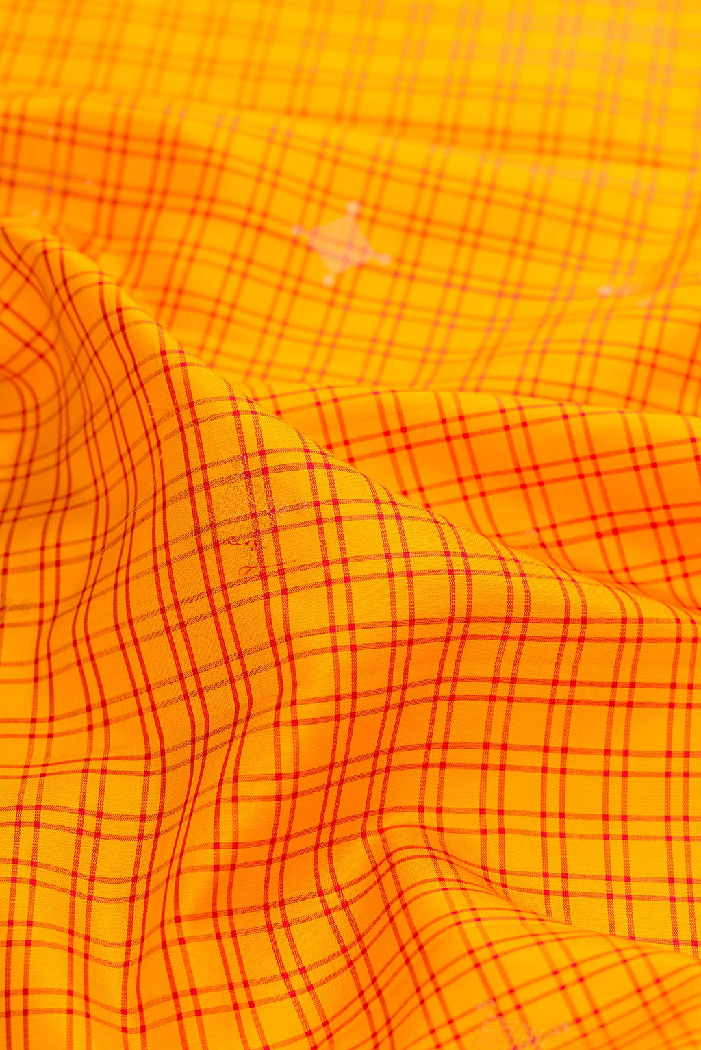 Close up of Yellow Soft Silk Saree with Checked design on the body and Thread Border displaying folds