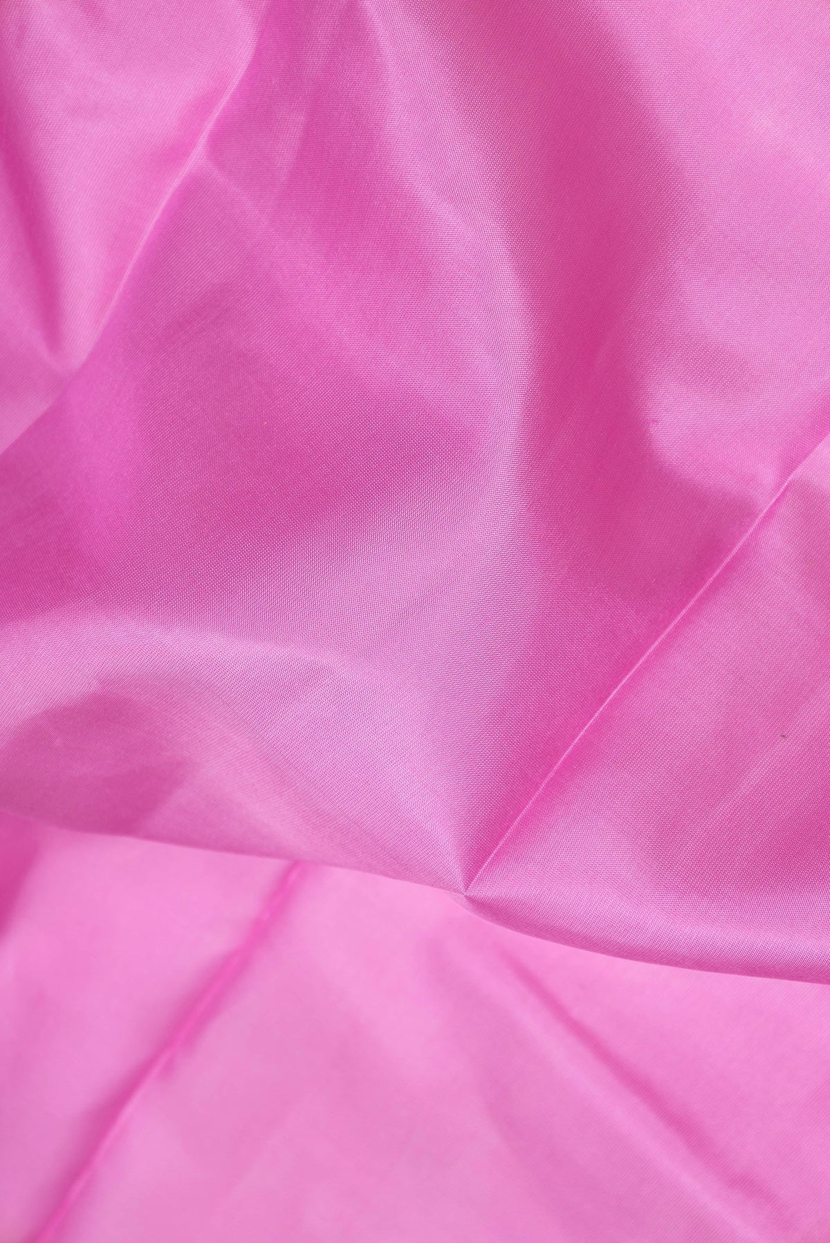 Close up of Pink Dual Tone Kanchipuram Silk Saree with Zari Butta on the body and Zari Border.  displaying folds