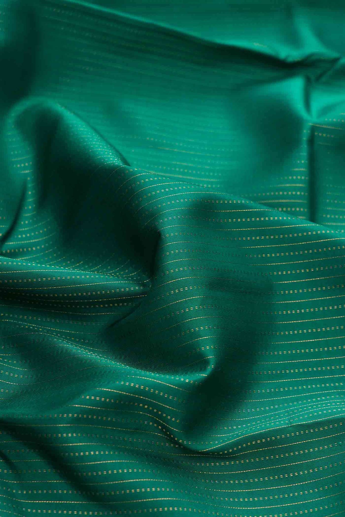 Close up of Green Dual Tone Kanchipuram Silk Saree with Stripes on the body and Zari Border displaying folds