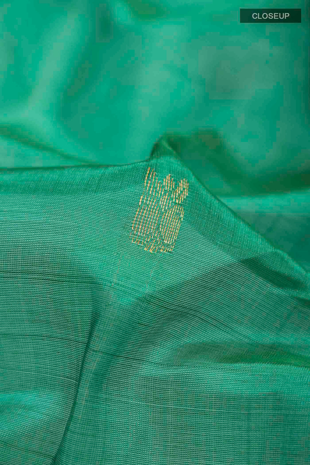 Close up of Green Silk Cotton Saree with Zari Butta on the body and Zari Border displaying folds