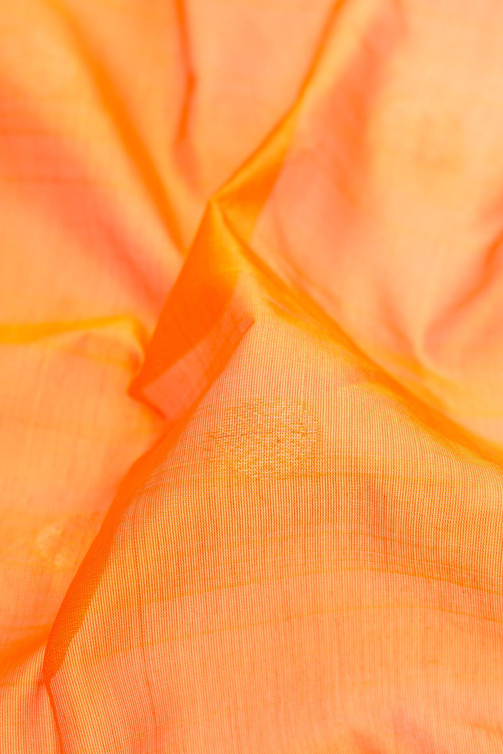 Close up of Orange Silk Cotton Saree with Zari Butta on the body and Zari Border.  displaying folds