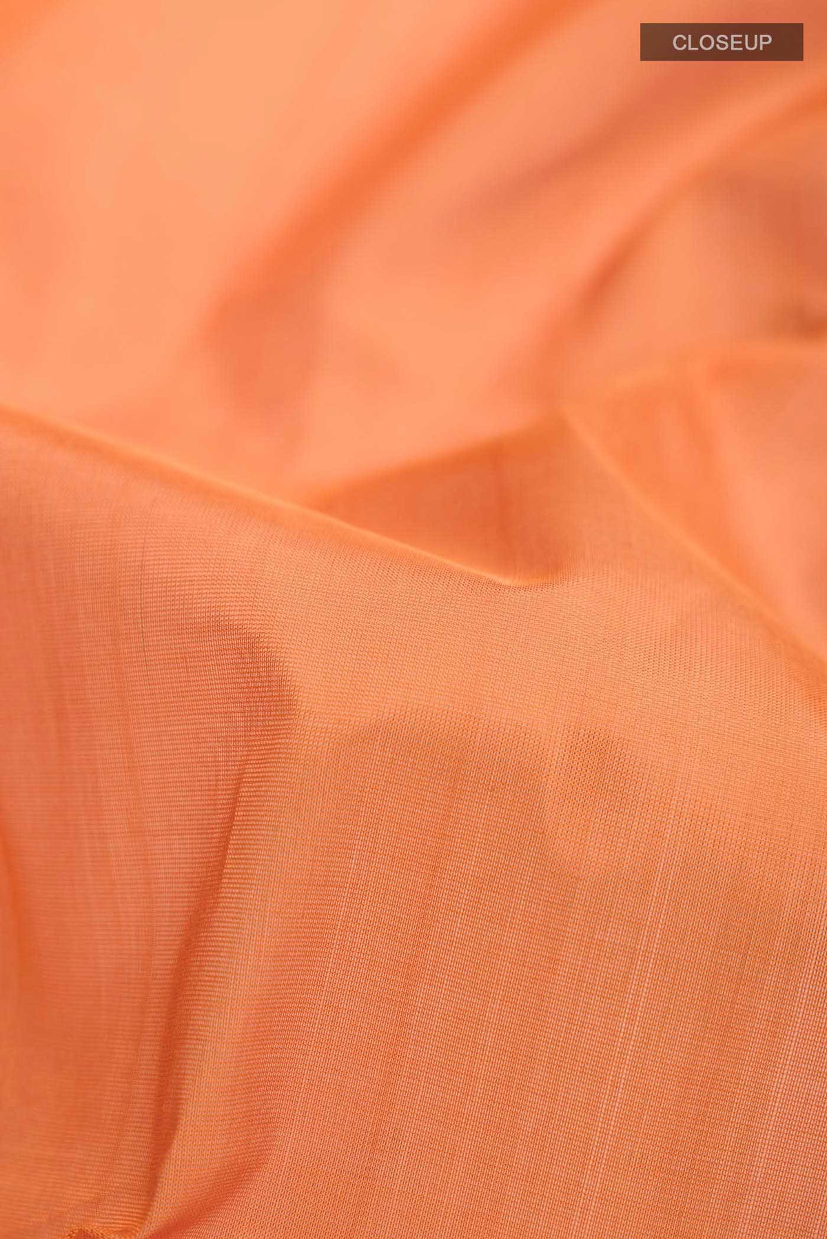 Close up of Orange Silk Cotton Saree with Plain Body and Zari Border displaying folds