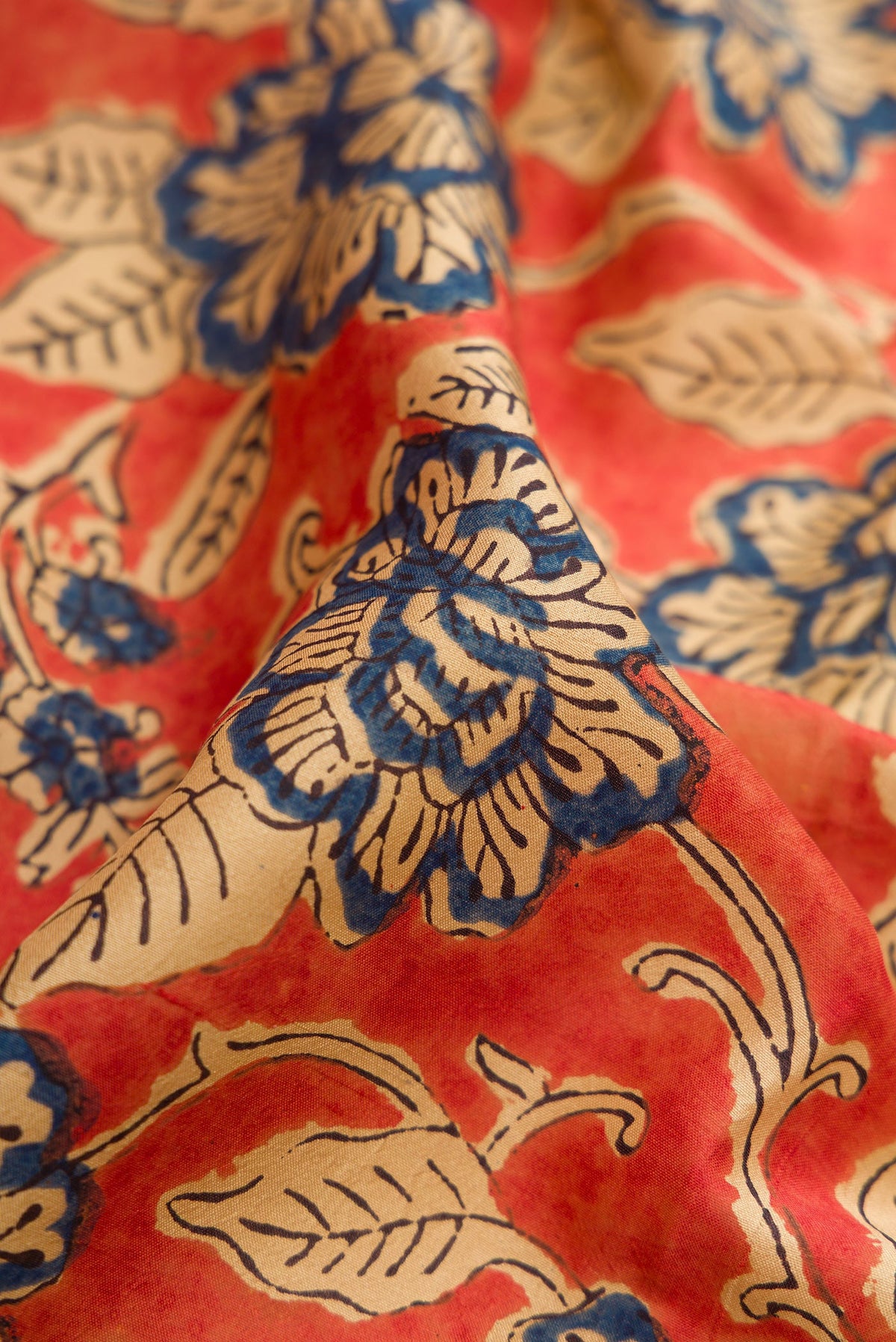 Close up of Orange Printed Silk Saree with Printed design on the body and Printed Border.  displaying folds
